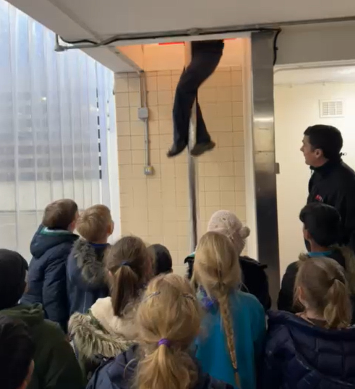Beavers watching a firefighter sliding down the pole